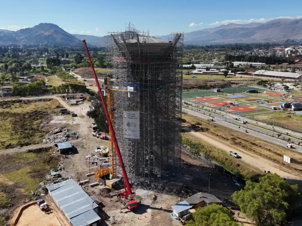 Grúa torre pesada realizando izaje en campamento minero a gran altura.